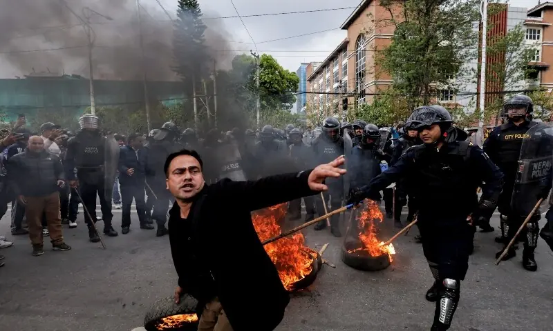 A demonstrator attempts to hurl a flaming tyre as police try to stop him during a protest following Nepal&rsquo;s former prime minister and Chairman of the Communist Party of Nepal, K P Sharma Oli&rsquo;s detention by police in Kathmandu, Nepal on March 28, 2026. &mdash; Reuters
