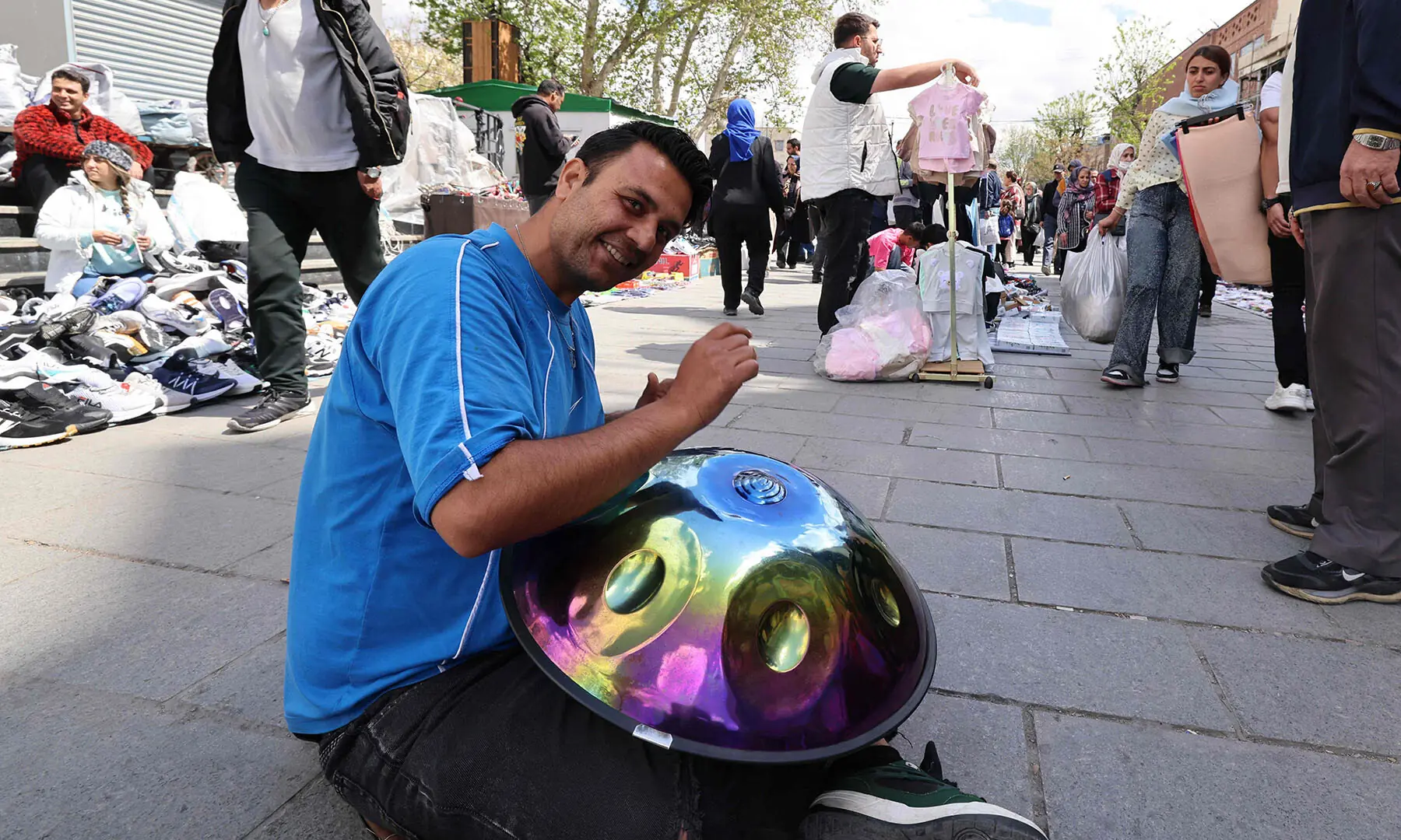 A man plays music as people walk at the Grand Bazaar in Tehran, Iran on March 30. &mdash; AFP