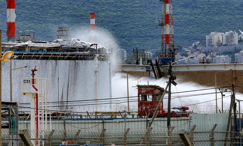Firefighters extinguish a blaze after a projectile struck a refinery in Israel’s northern city of Haifa.—AFP Firefighters extinguish a blaze after a projectile struck a refinery in Israel’s northern city of Haifa.—AFP