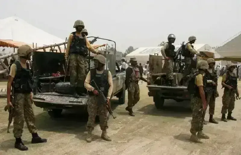 In this file photo, Pakistan Army soldiers stand guard as people receive relief goods from the army in Bannu on July 2, 2014. &mdash; Reuters