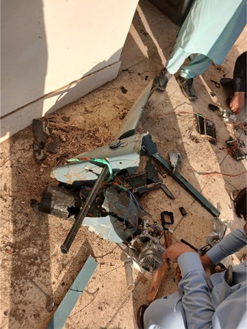PEOPLE examine the wreckage of a drone that fell in Attock.&mdash;Dawn