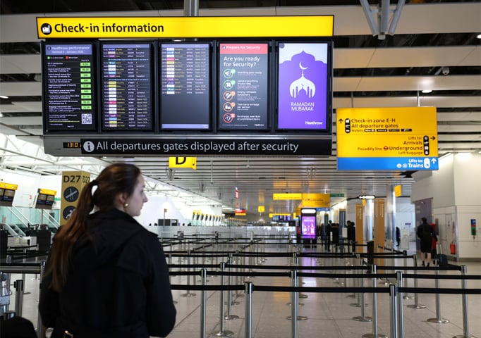 London: A traveller looks at a departure board displaying cancelled flights to Middle East countries at Heathrow Airport.&mdash;Reuters