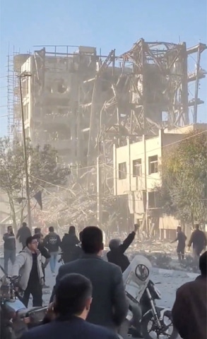  People gather around the destroyed building of Iran&rsquo;s Assembly of Experts in Qom. Iranian media reports claimed that the building was no lon&shy;ger being used for meetings. &mdash;AFP / Reuters 