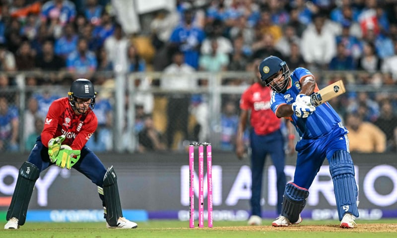 INDIAN opener Sanju Samson hits out as England wicket-keeper Jos Buttler watches during their semi-final at the Wankhede Stadium on Thursday.&mdash;AFP