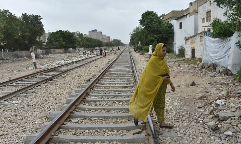 A woman walks across a railway track in Moria Khan Goth: a decades-old dispute with Pakistan Railways has reportedly left 250 of the 20,000 plus households in Moria Khan Goth in a state of existential limbo
