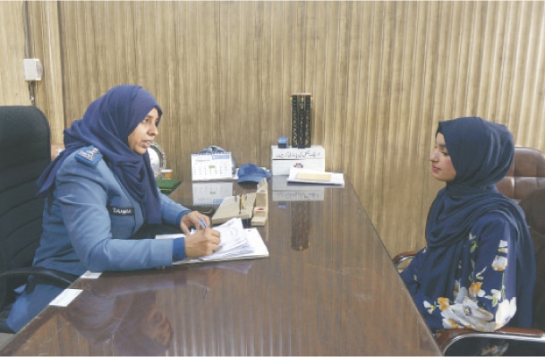 A police instructor fills the form of an applicant seeking admission to scooty driving classes.