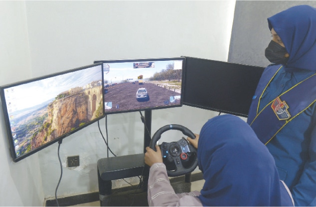 A learner uses a simulator to perfect her driving skills.