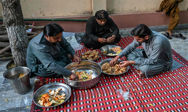 Hindu men prepare Iftar inside a Sufi shrine in Mithi.&mdash;AFP