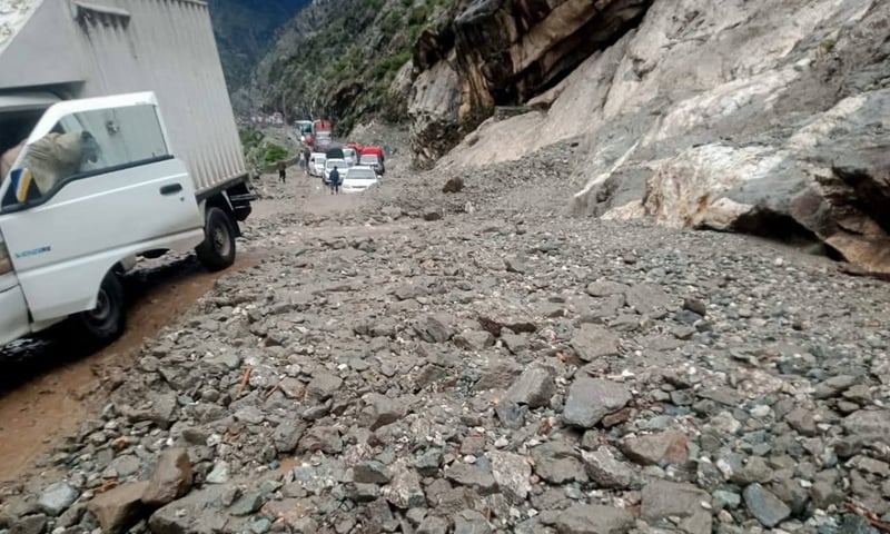 Motorists stranded on Karakoram Highway after a landslide in Upper Kohistan on Wednesday. (Right) Power lines lying on the road after heavy rain and windstorm in Yakhtangay area of Puran tehsil, Shangla. &mdash; Dawn