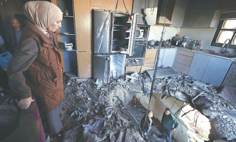 PALESTINIANS assess damage caused by fragments of an intercepted rocket that landed on a three-storey building in the occupied West Bank town of Bidya.—AFP PALESTINIANS assess damage caused by fragments of an intercepted rocket that landed on a three-storey building in the occupied West Bank town of Bidya.—AFP