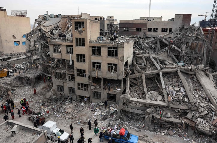  TEHRAN: Rescue workers gather as residents collect their belongings from the rubble of a residential building, damaged by US-Israeli strikes.&mdash;AFP 
