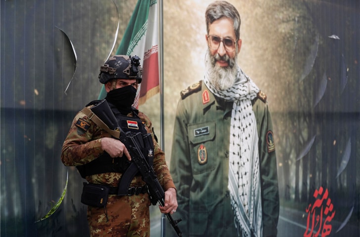 A member of Hashed al-Shaabi Forces stands in front of a banner depicting a younger Ayatollah Ali Khamenei, at Baghdad&rsquo;s Tahrir Square.&mdash;AFP