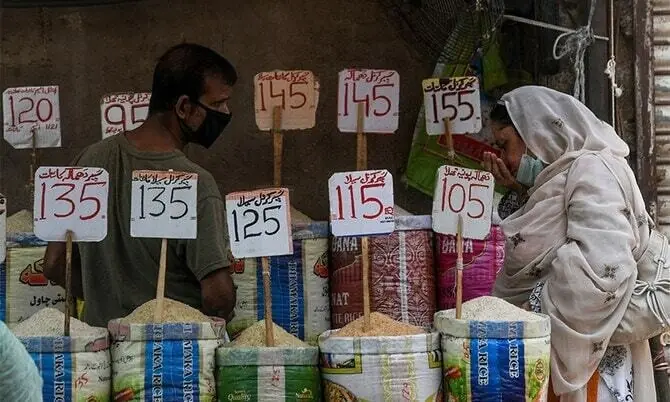 A woman checks rice at a market in Karachi in this file photo. &mdash; AFP/File