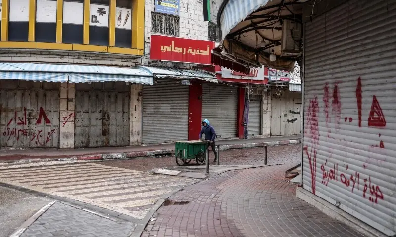 A man pushes a street stall through an empty street in Ramallah, in the Israeli-occupied West Bank, on April 1, 2026, during a general strike to protest a bill approved by the Israel’s parliament. — AFP A man pushes a street stall through an empty street in Ramallah, in the Israeli-occupied West Bank, on April 1, 2026, during a general strike to protest a bill approved by the Israel’s parliament. — AFP