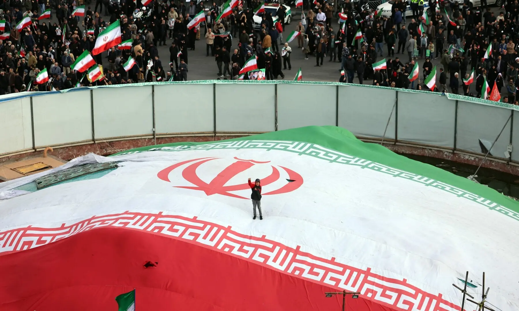 A boy raises his fist while standing on a giant Iranian flag during the funeral of Alireza Tangsiri, the assassinated commander of the Iranian Revolutionary Guards&rsquo; navy, in Enghelab Square in Tehran, Iran on April 1. &mdash; AFP