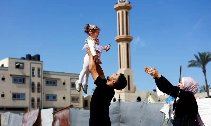 Maternal uncle of Bissan, who was evacuated as a premature baby during the two-year Israeli offensive for treatment in Egypt, plays with her after she returned to Gaza as her Palestinian mother Sundus al-Kurd reaches her arms out, in Deir al-Balah in the central Gaza Strip on March 31, 2026. — Reuters Maternal uncle of Bissan, who was evacuated as a premature baby during the two-year Israeli offensive for treatment in Egypt, plays with her after she returned to Gaza as her Palestinian mother Sundus al-Kurd reaches her arms out, in Deir al-Balah in the central Gaza Strip on March 31, 2026. — Reuters