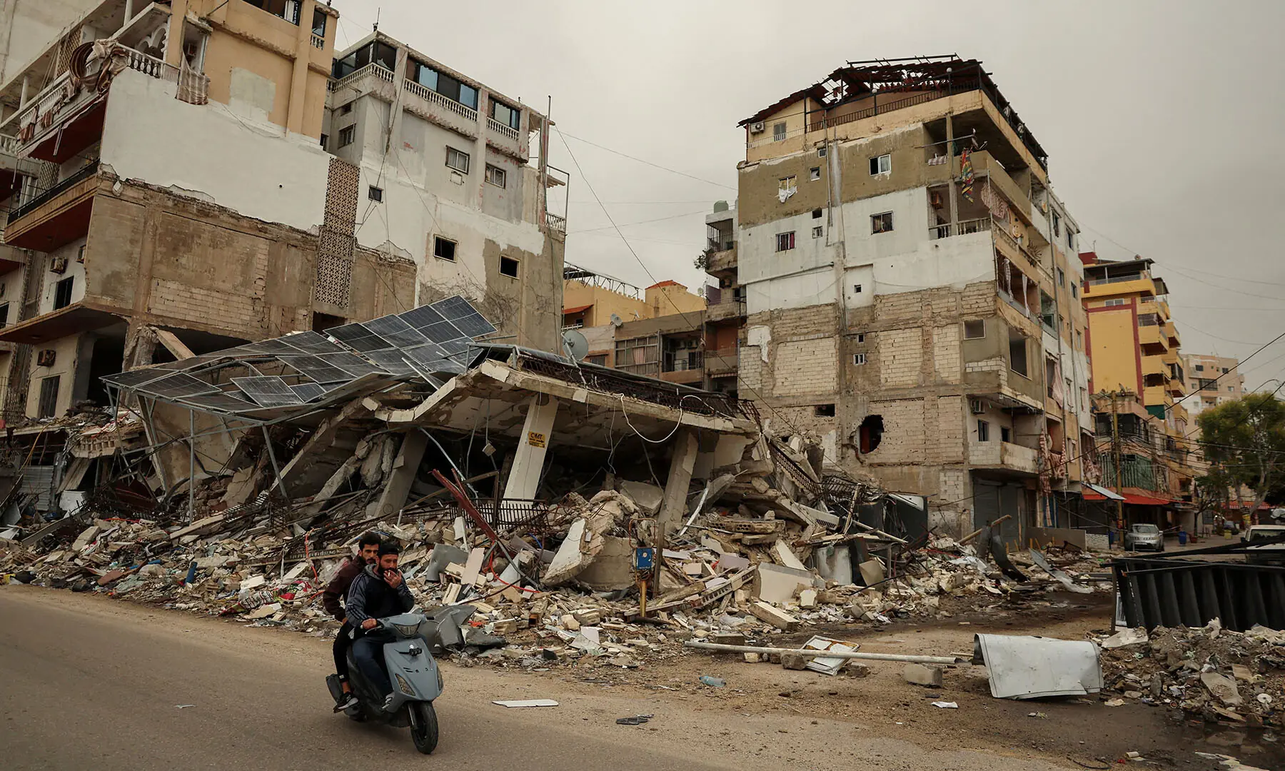 Men ride a scooter past the rubble of a building destroyed by an Israeli strike, amid escalating hostilities between Israel and Hezbollah, in Tyre, Lebanon on April 2. &mdash; Reuters