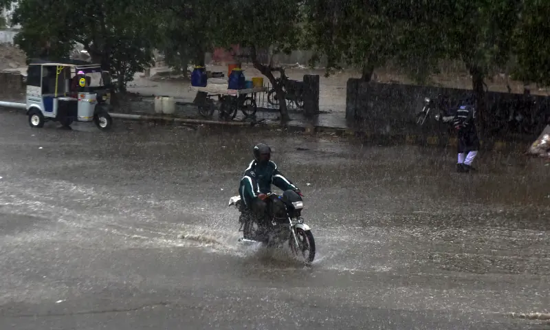 A man drives a motorcycle along a flooded road in Karachi amid heavy rain on April 2. &mdash; White Star