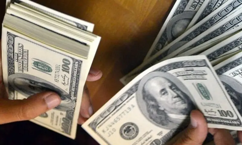 This file photo shows a man holding stacks of the US dollar. &mdash; AFP/File