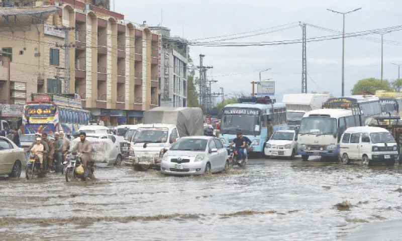 Vehicular traffic pass through rainwater accumulated on Col Sher Khan Shaheed Road near Fazaabad in Islamabad after heavy rain. &mdash; Photo by Mohammad Asim