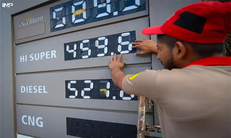 An employee of a fuel station updates the latest petrol and diesel prices on a board in the city on Friday.&mdash;INP