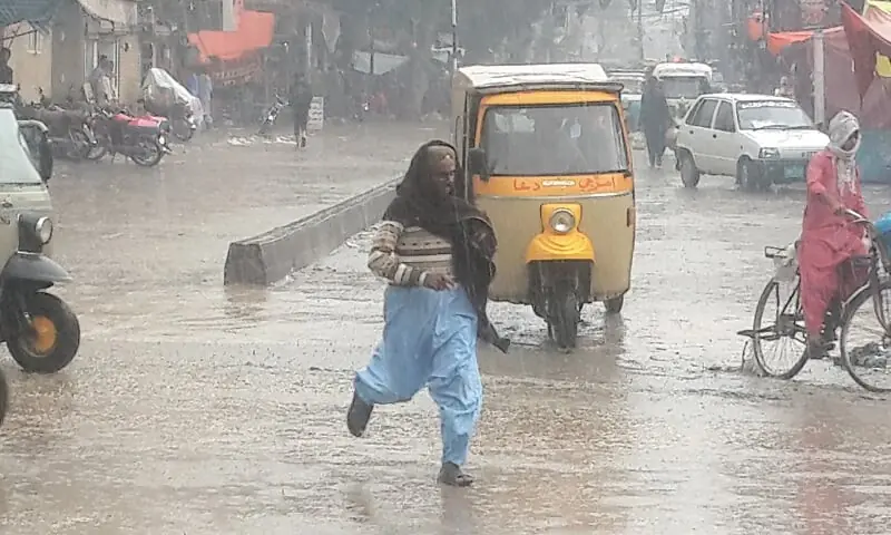 A MAN crosses a road during a heavy spell of rainfall in Larkana. —Dawn/File A MAN crosses a road during a heavy spell of rainfall in Larkana. —Dawn/File
