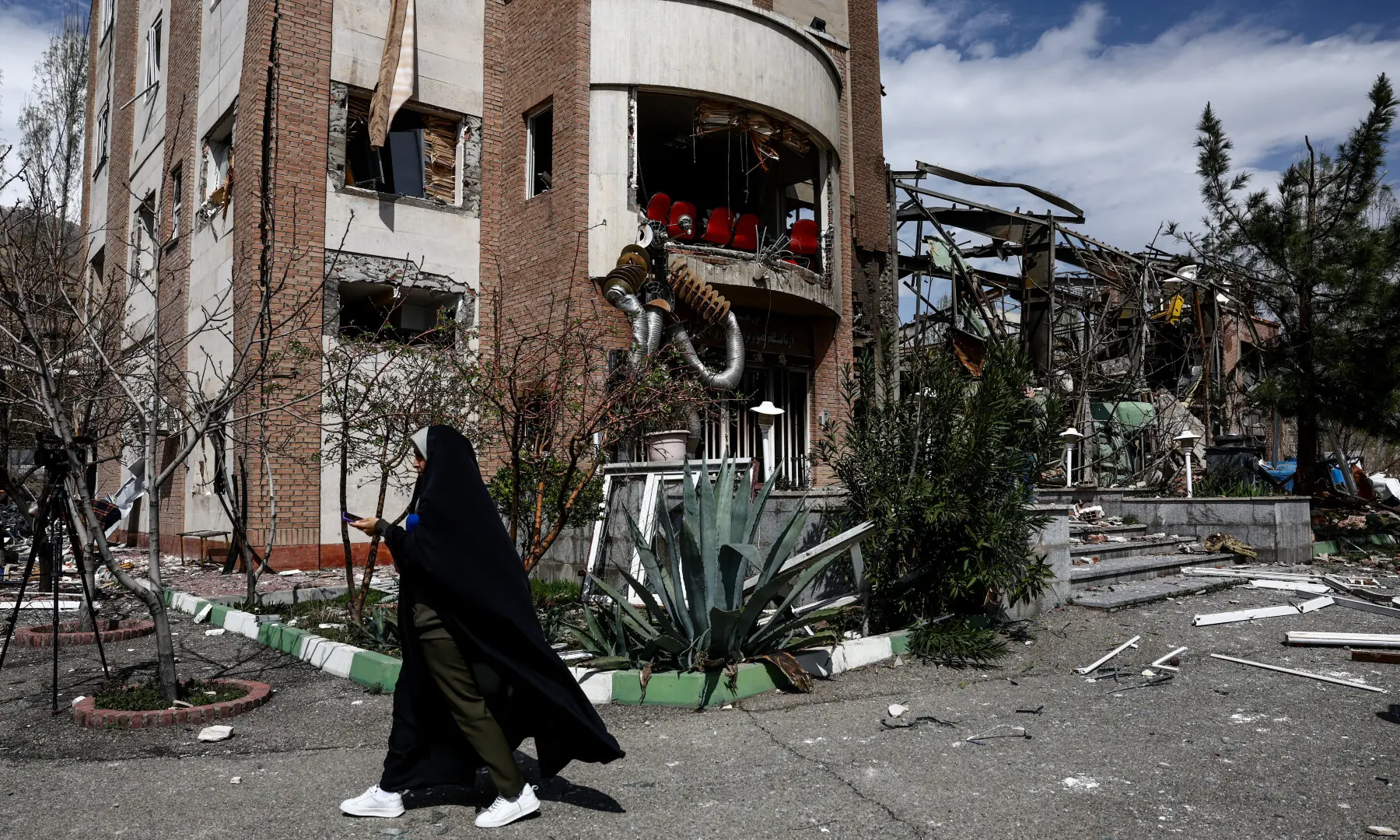 A woman walks past the research building of the Shahid Beheshti University, which was damaged by a US-Israeli strike, in Tehran, Iran on April 4, 2026. &mdash; WANA via Reuters
