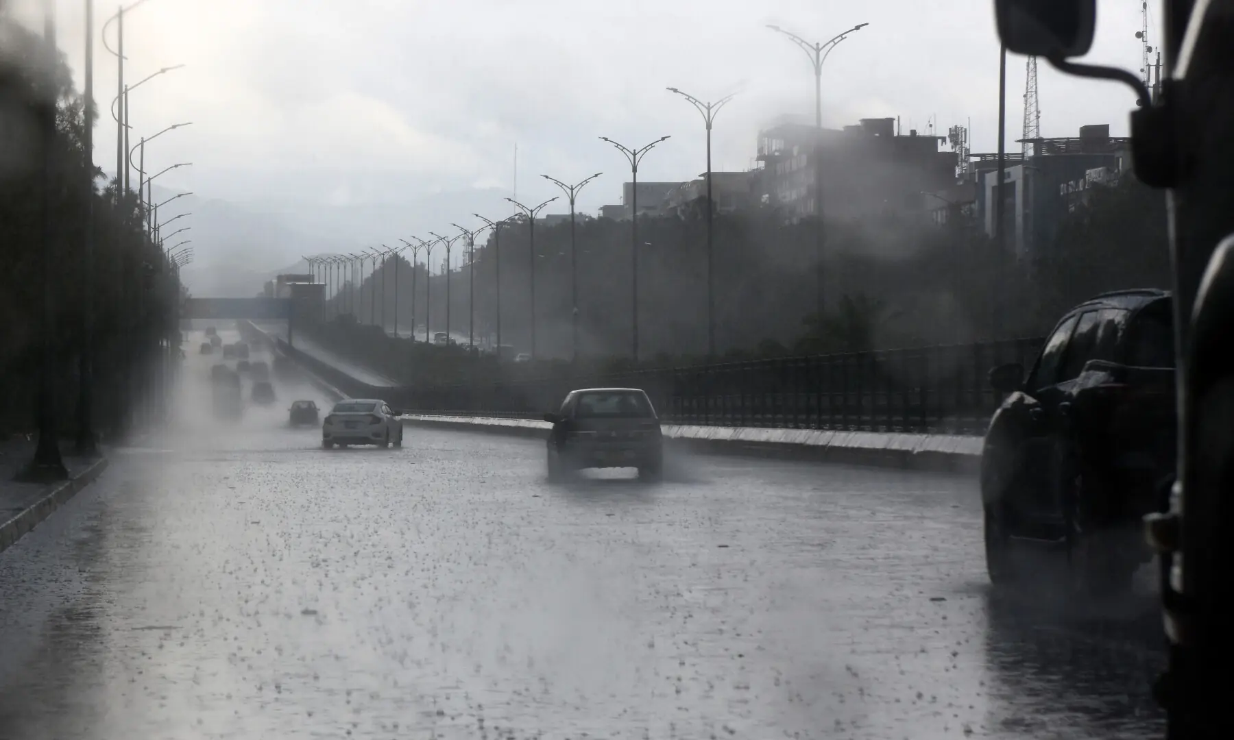 Vehicles ply on a road in Islamabad during rainfall on April 4, 2026. &mdash; Tanveer Shahzad/White Star