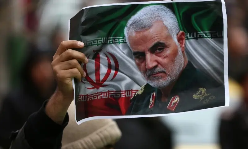 An Iranian holds a picture of late General Qassem Soleimani as people gather to mourn him in Tehran, Iran on January 4, 2020. &mdash; Reuters