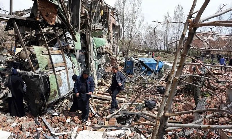 Officials and media representatives gather around the damaged building of the Shahid Beheshti University following a strike, in Tehran on April 4. &mdash; AFP