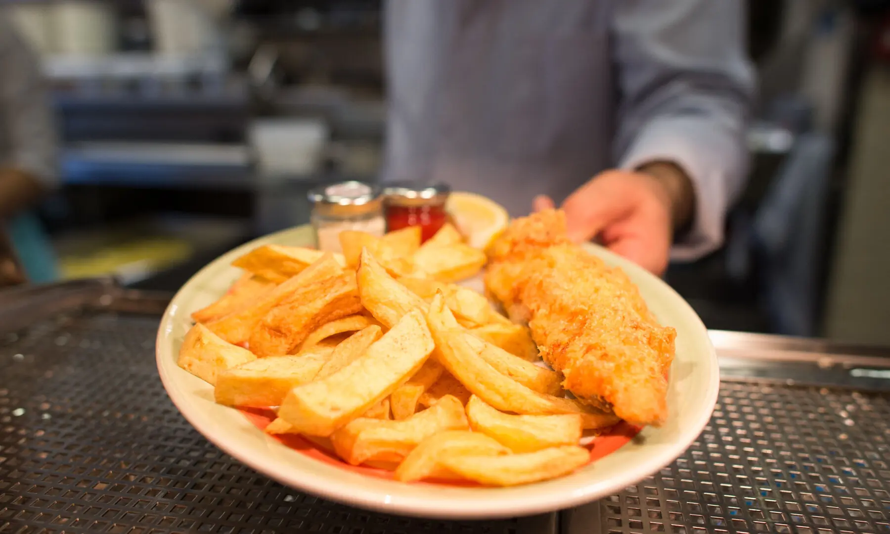 A chef poses with a plate of fish and chips at Poppies fish and chip restaurant in east London on January 26, 2015. &mdash; AFP/File