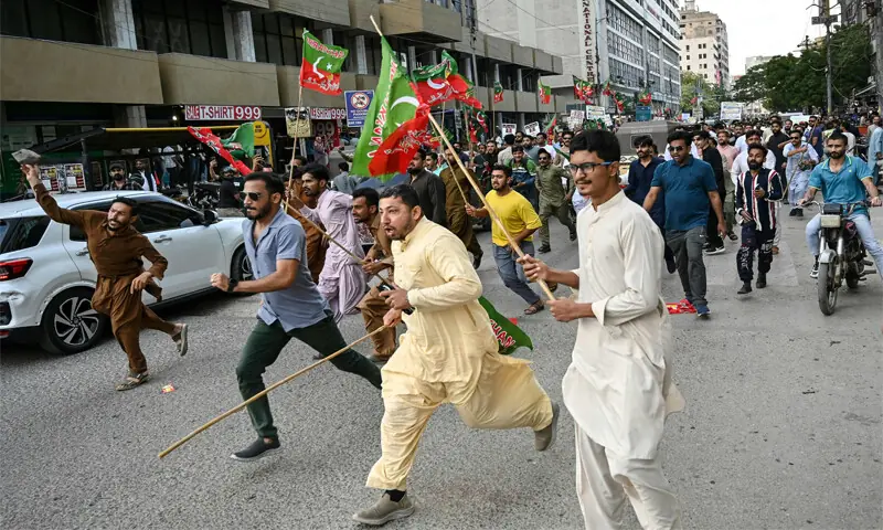 PTI workers clash with police (not visible in the picture) near the Karachi Press Club.—AFP PTI workers clash with police (not visible in the picture) near the Karachi Press Club.—AFP