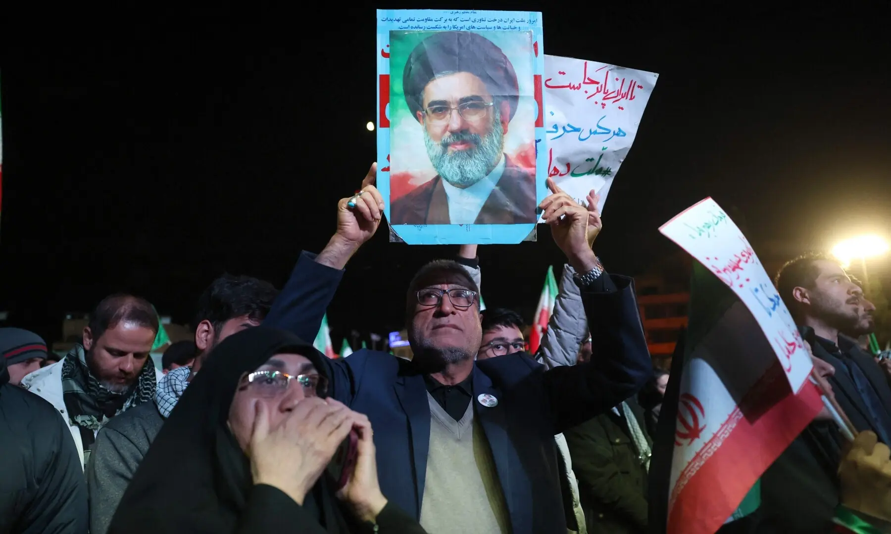 An Iranian man holds up picture of Iranian supreme leader Ayatollah Mojataba Khamenei as others react to a ceasefire announcement at the Enqelab square, in Tehran, on April 8 2026. &mdash;AFP