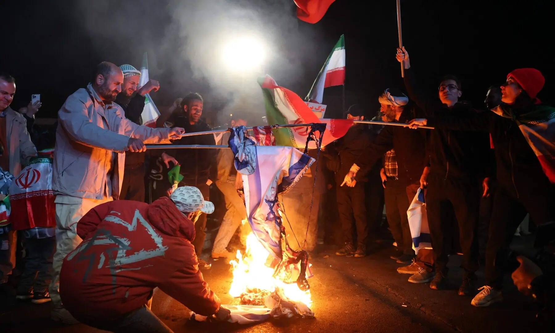 Iranians burn US and Israeli flags as react after the ceasefire announcement at the Enqelab square, in Tehran, on April 8, 2026. &mdash;AFP