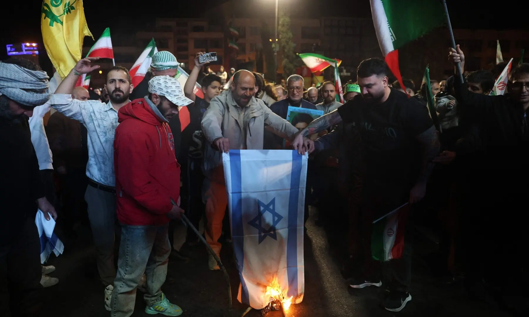 Iranians burn US and Israeli flags as react after the ceasefire announcement at the Enqelab square, in Tehran, on April 8, 2026. &mdash;AFP