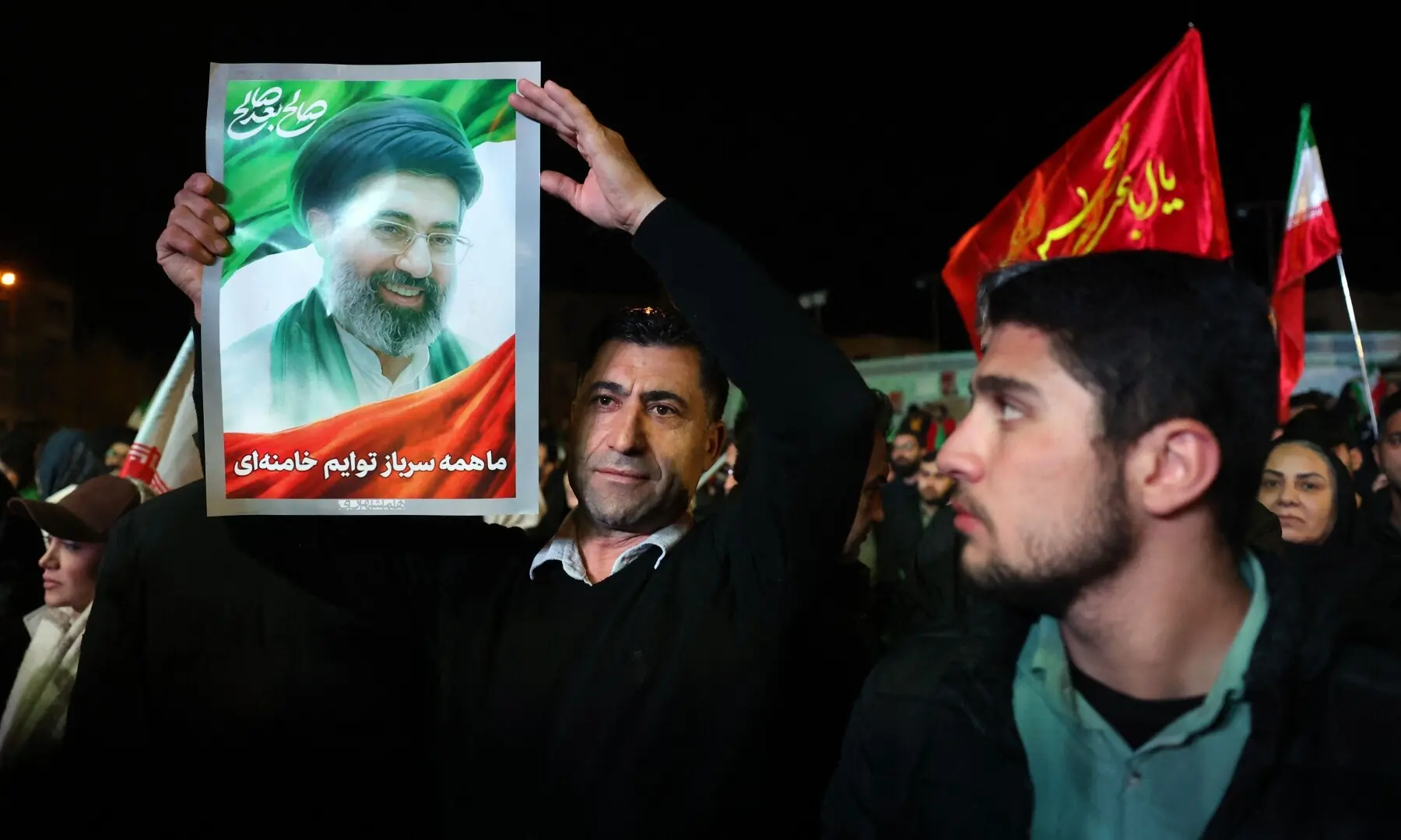 An Iranian man holds up picture of Iranian supreme leader Ayatollah Mojataba Khamenei as others react to a ceasefire announcement at the Enqelab square, in Tehran, on April 8 2026. &mdash;AFP