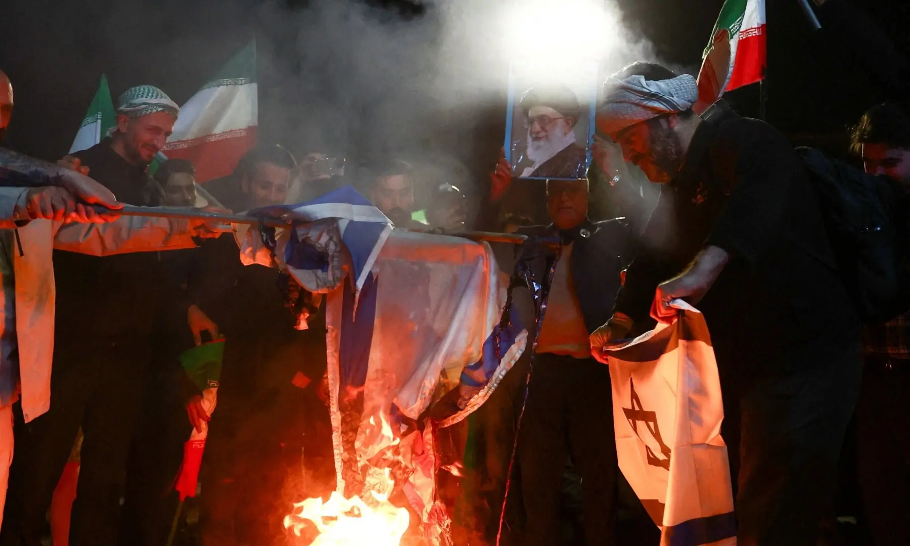 People burn the flags of the US and Israel as they gather after a two-week ceasefire in the Iran war was announced, in Tehran, Iran, April 8, 2026. &mdash;Reuters