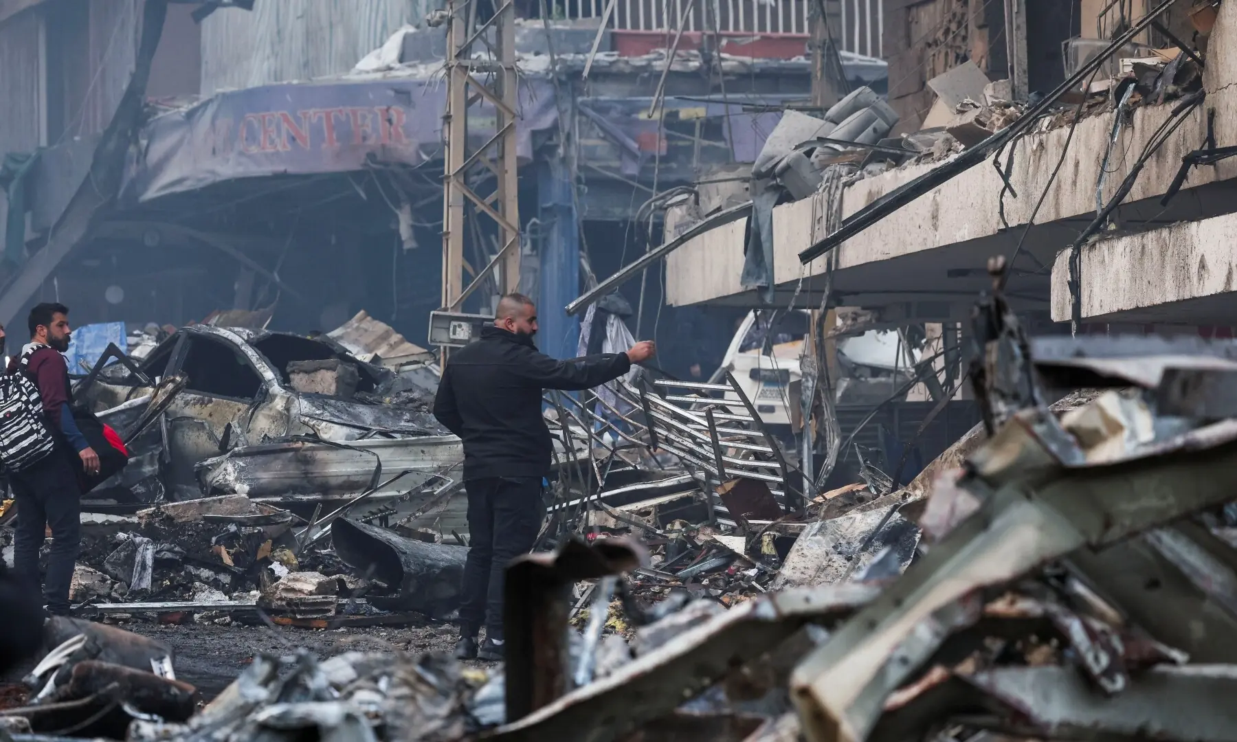People stand at the site of an Israeli strike, in Al-Mazraa in Beirut, Lebanon on April 8. &mdash; Reuters