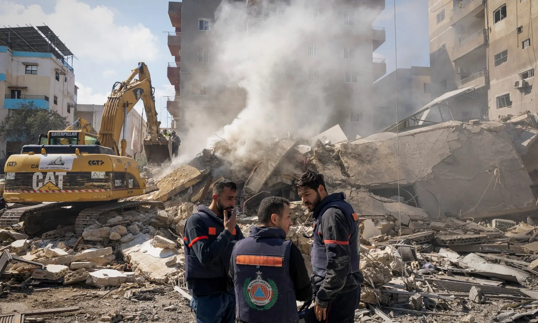 Rescue workers stand next to the rubble at the site of an Israeli strike in Tyre, Lebanon on April 8. &mdash; Reuters