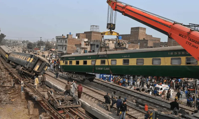 Rescue workers, along with railway personnel, use a crane to clear the tracks after a train derailed near Lahore on January 31. &mdash; AFP/File