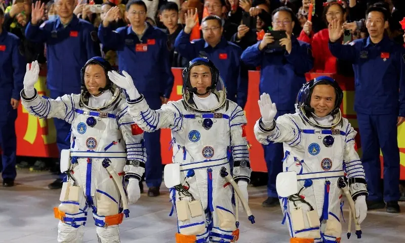 Astronauts Zhang Hongzhang, Wu Fei, and Zhang Lu wave during a see-off ceremony before taking part in the Shenzhou-21 spaceflight mission to China&rsquo;s Tiangong space station, at  Jiuquan Satellite Launch Center, near Jiuquan, Gansu province, China October 31, 2025. &mdash;Reuters/File