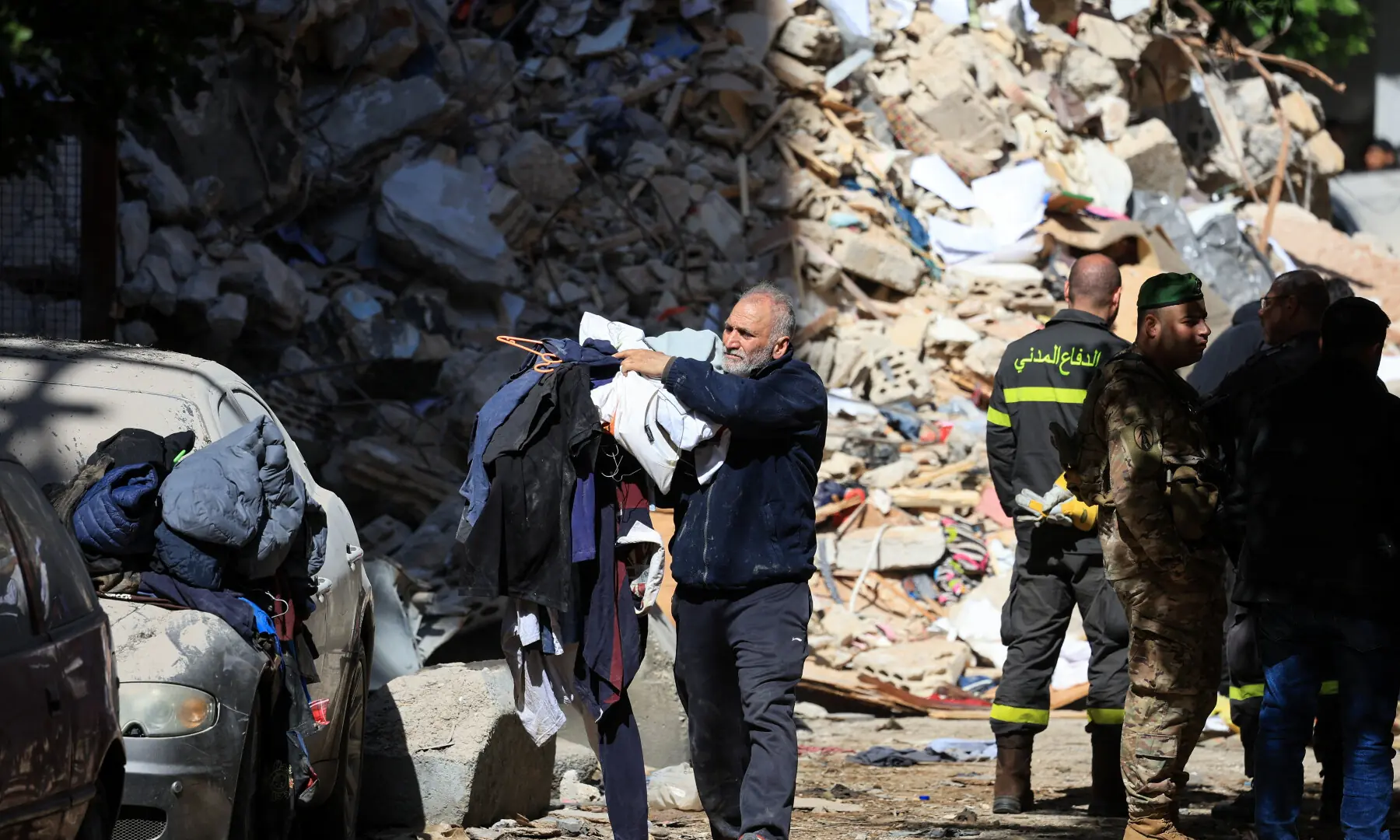 A man carries pieces of clothing at the site of an Israeli strike carried out on Wednesday, in Ain Al Mraiseh in Beirut, Lebanon on April 9, 2026. &mdash; Reuters