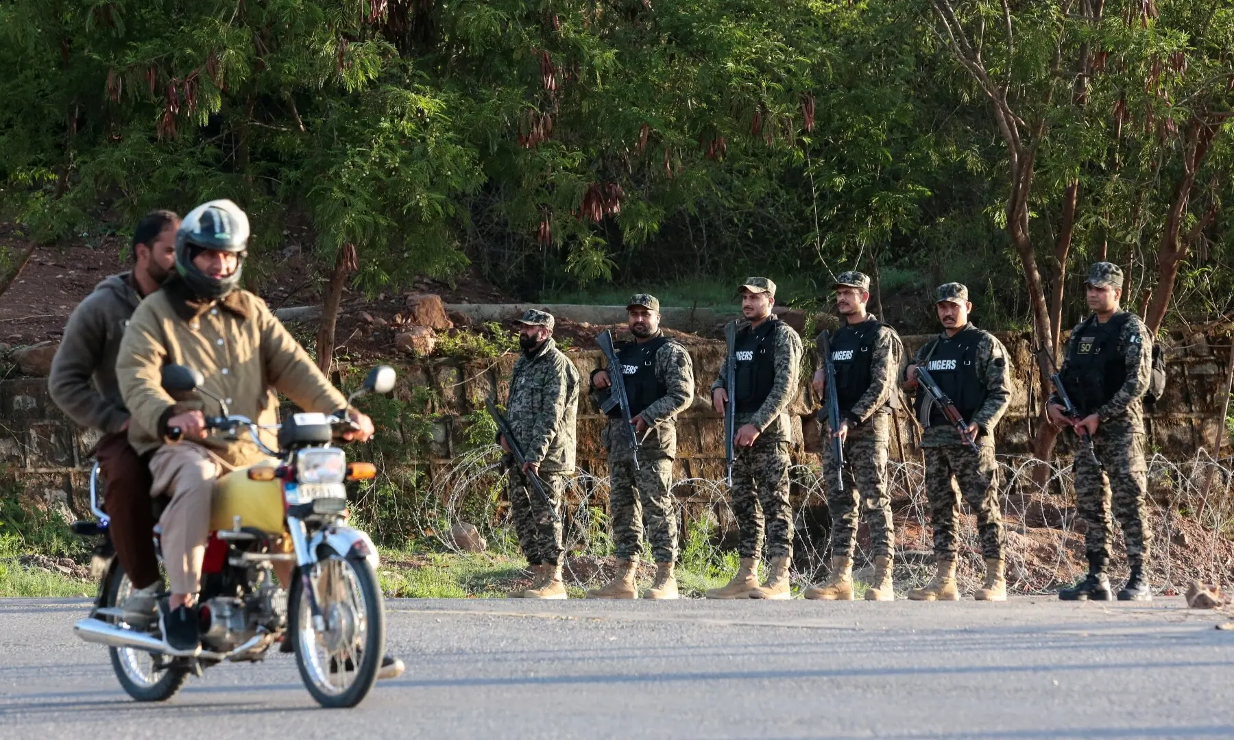 A man rides a motorcycle past Pakistani Rangers standing guard and securing the Red Zone area, as Pakistan prepares to host the US and Iran for peace talks, in Islamabad, Pakistan, April 10, 2026. &mdash;Reuters