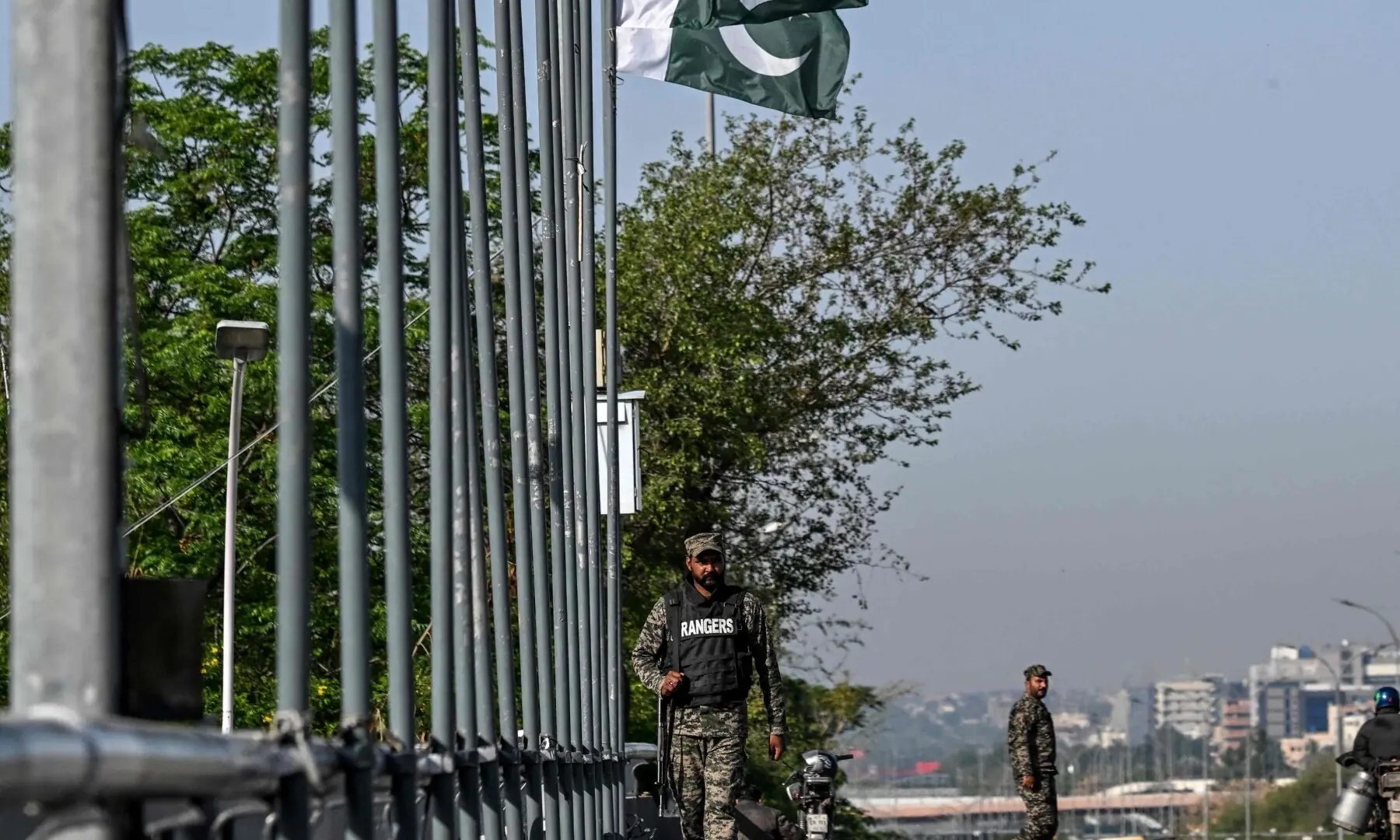 Paramilitary soldiers stand guard beside the Pakistani national flags along a street in Islamabad on April 10, 2026. &mdash;AFP