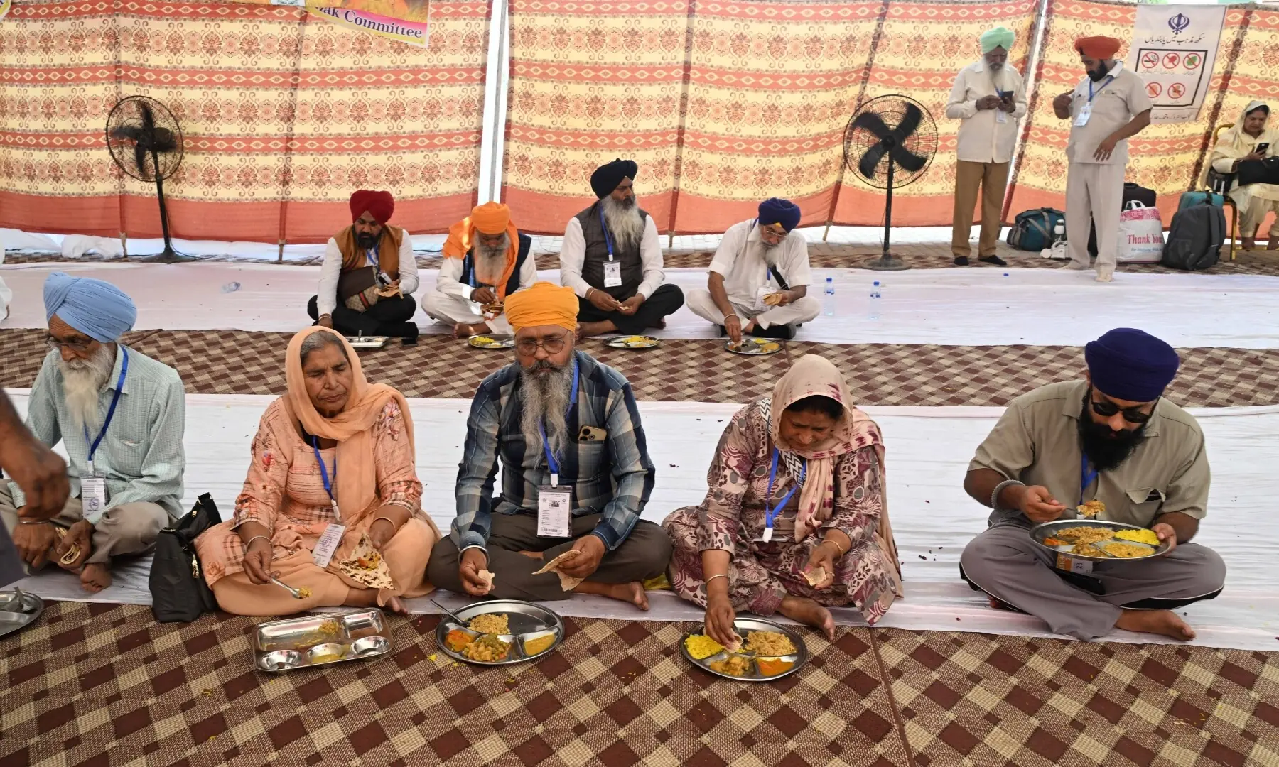 Sikh pilgrims eat food as they arrive in Pakistan from India via Wagah border on April 10, 2026. &mdash; White Star/ Arif Ali