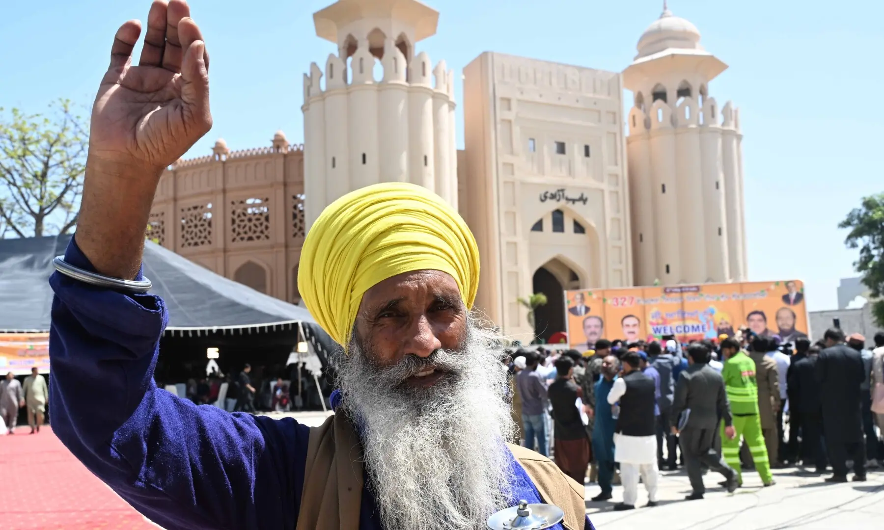 A Sikh pilgrim waves as the first batch arrives in Pakistan from India via Wagah border on April 10, 2026. &mdash; White Star/ Arif Ali