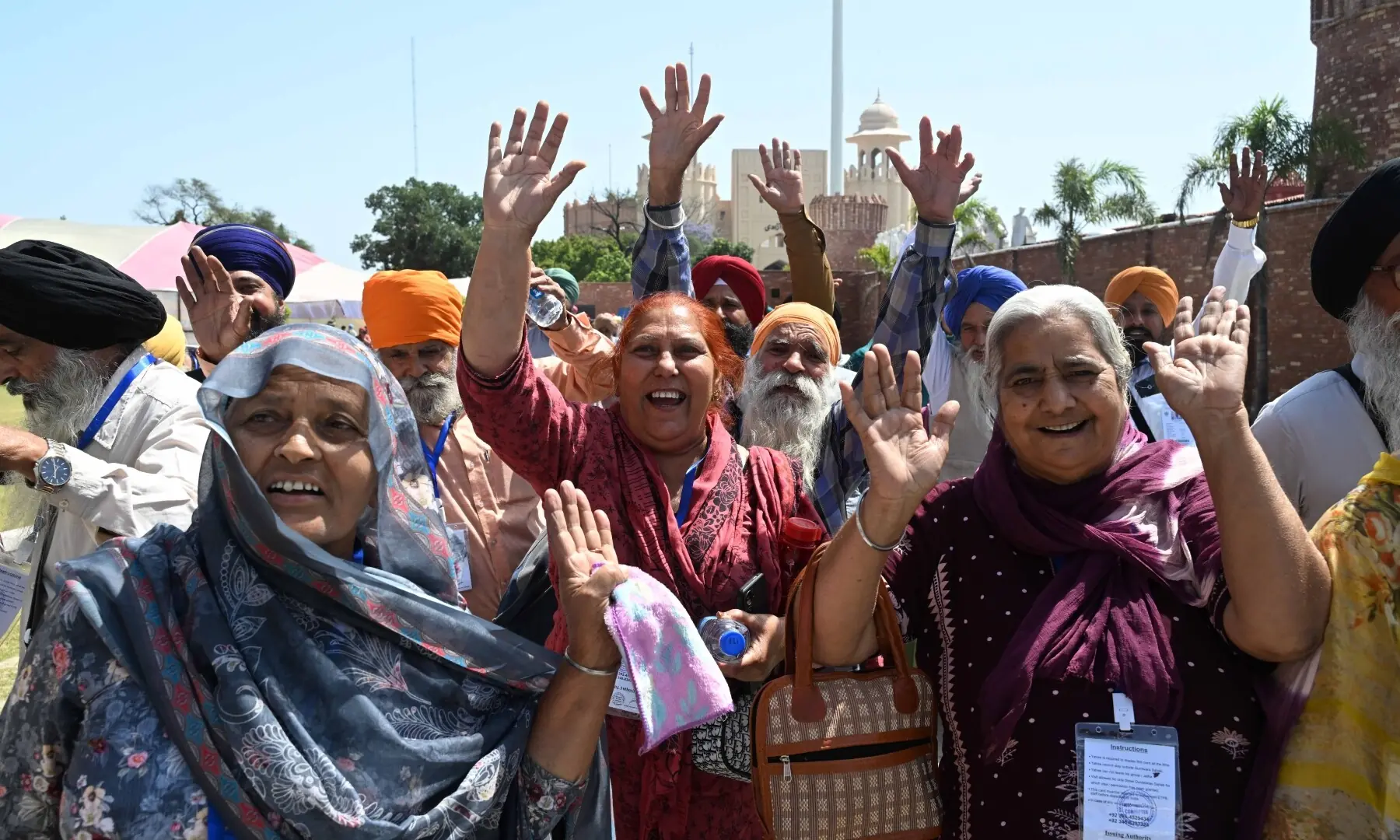Sikh pilgrims wave as they arrive in Pakistan from India via Wagah border on April 10, 2026. &mdash; White Star/ Arif Ali