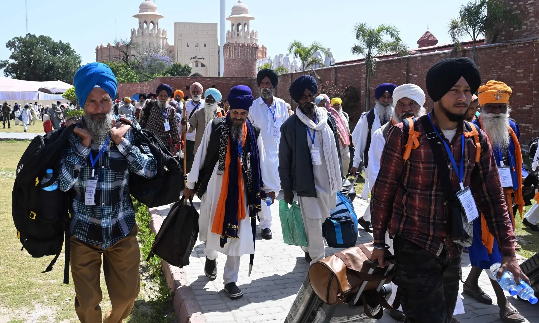 Sikh pilgrims carry their luggage as they arrive in Pakistan from India via Wagah border on April 10, 2026. &mdash; White Star/ Arif Ali