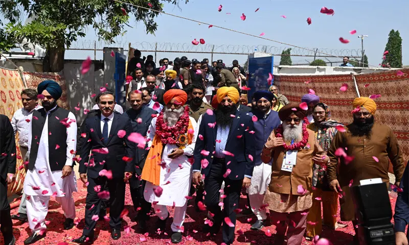 SIKH pilgrims are showered with rose petals as they arrive in Pakistan from India via Wagah border near Lahore.—M. Arif / White Star SIKH pilgrims are showered with rose petals as they arrive in Pakistan from India via Wagah border near Lahore.—M. Arif / White Star