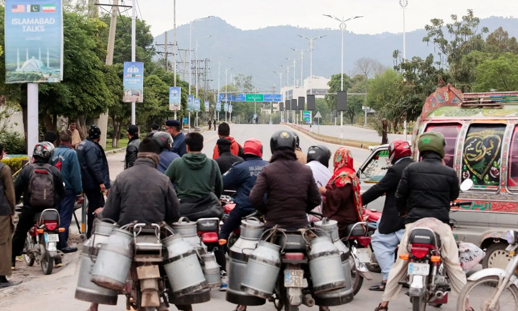 Commuters sit on bikes at a roadblock leading to the Serina Hotel, as delegations from the United States and Iran are expected to hold peace talks in Islamabad, Pakistan, April 11, 2026. &mdash;AFP